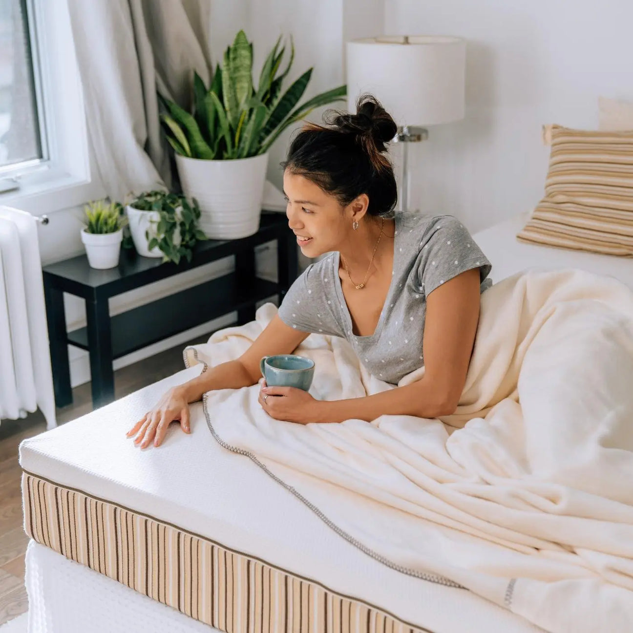 A woman laying on an Essentia mattress