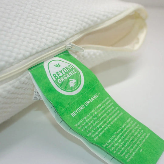 A close-up of an Essentia mattress tag and the pillow in a partially unzipped pillow case