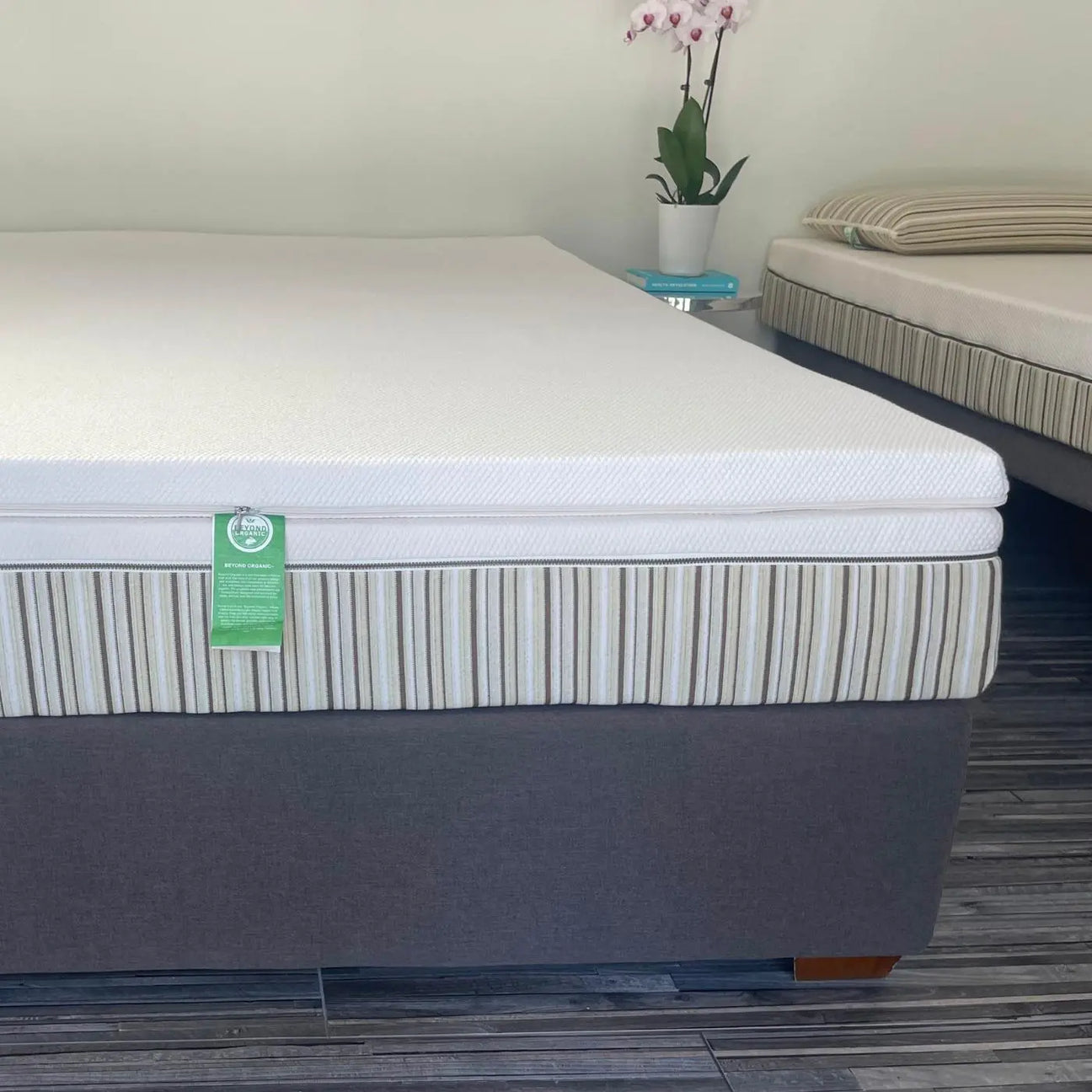 Essentia bedding and sheets on a mattress propped up against pillows